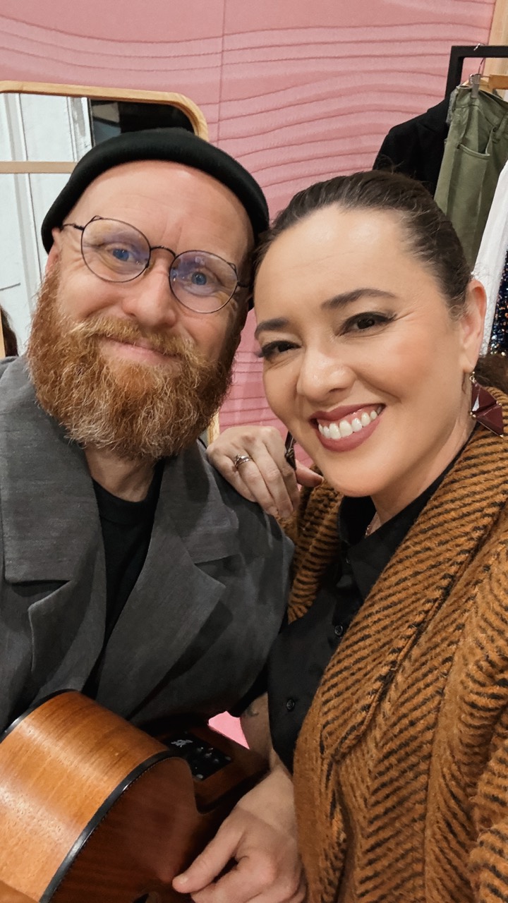 Tim and Josie smiling together with an acoustic guitar between sets